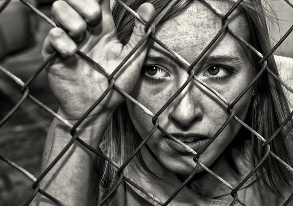 Vrouw achter hek — Stockfoto