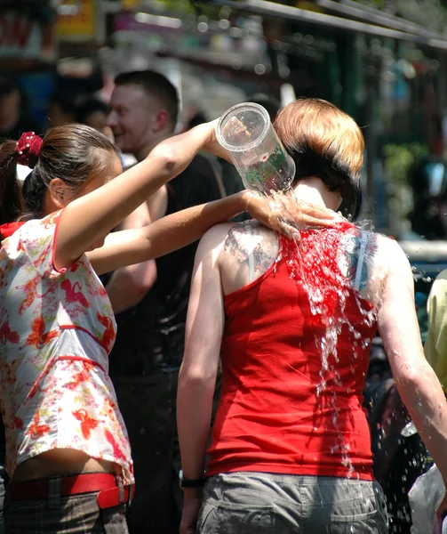 Thailand water festival - vrouw giet water over toeristen. — Stockfoto
