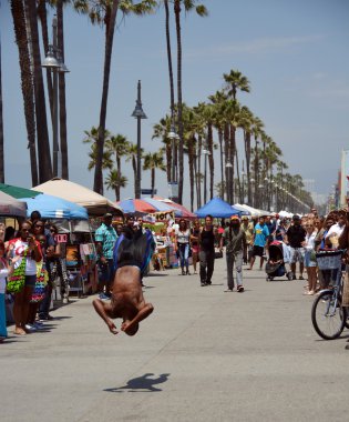 Acrobat venice plajında hafta sonu ziyaretçi eğlendirir.