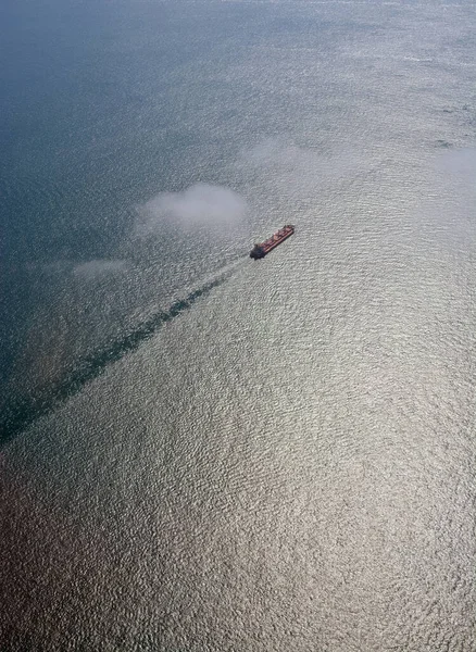 Merchant ship travelling on the smooth South China Sea, south of  Singapore.