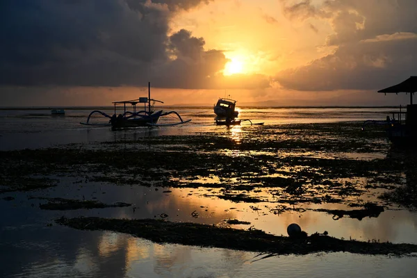 バリのサヌールビーチで夜明けのシルエットの漁船で上昇する太陽の黄金の輝きインドネシア — ストック写真