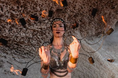 Kadın elinde ateş hayranıyla tutkulu bir şekilde dans ediyor. Kabile tarzı dansçı. Ateş gösterisi.