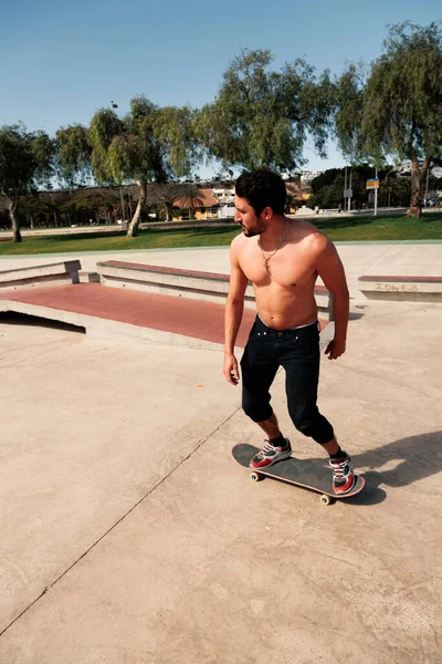 Homem andando de skate no parque de skate urbano de rua. Casual cara vestindo shorts e camiseta. — Fotografia de Stock