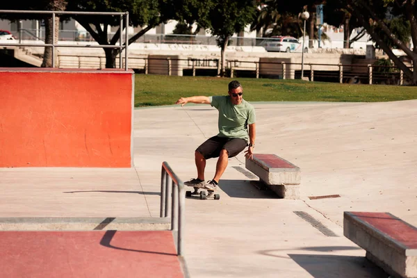 Man paardrijden skateboard in stedelijke straat skatepark. Casual man draagt korte broek en T-shirt. — Stockfoto