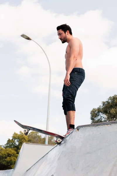 스케이트 램프 꼭대기에 서 있는 젊은 스케이트 선수 — 스톡 사진