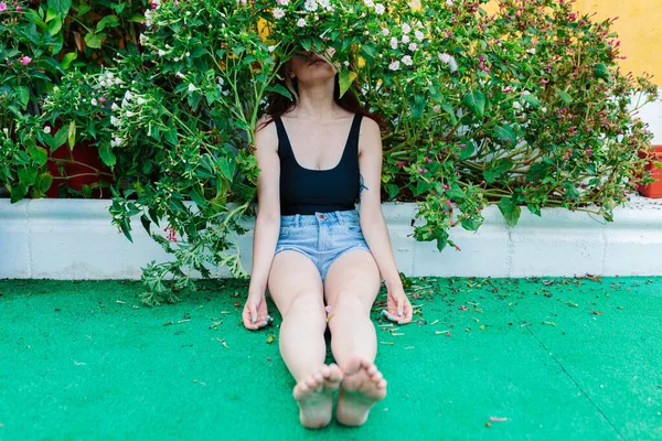 Bedachtzame vrouw die alleen buiten zit. Jong bezorgd in de achtertuin — Stockfoto