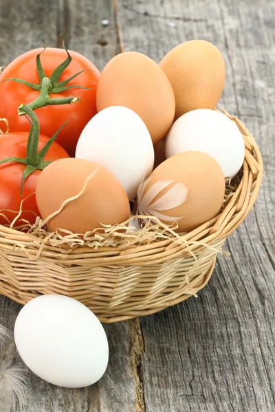 Huevos frescos y tomates en la cesta — Foto de Stock