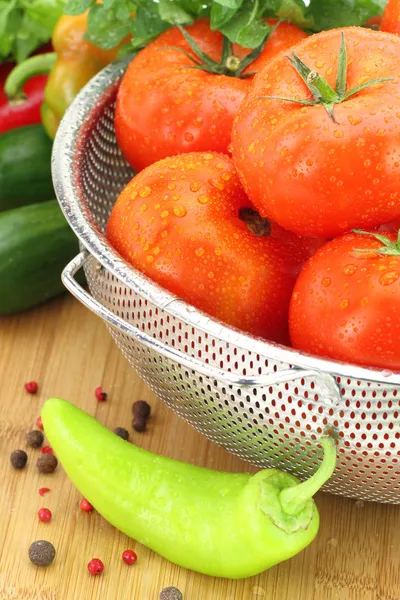 Fresh tomatoes in metal colander — Stock Photo, Image