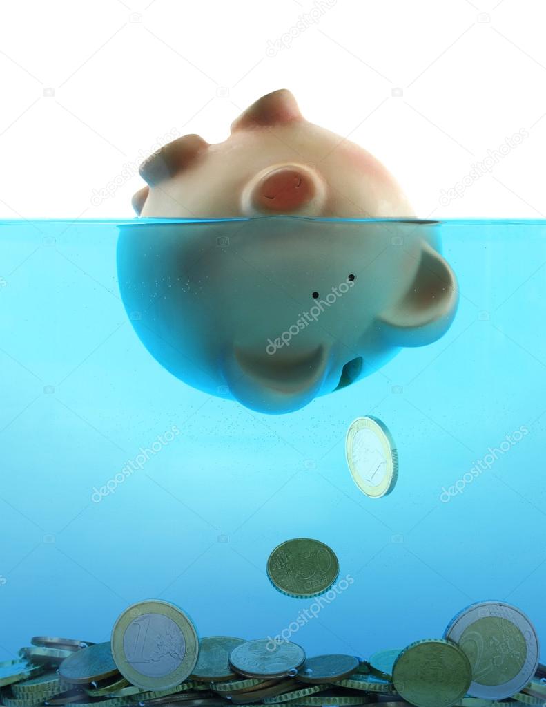 Drowning in debt represented by a piggy bank sinking in blue water