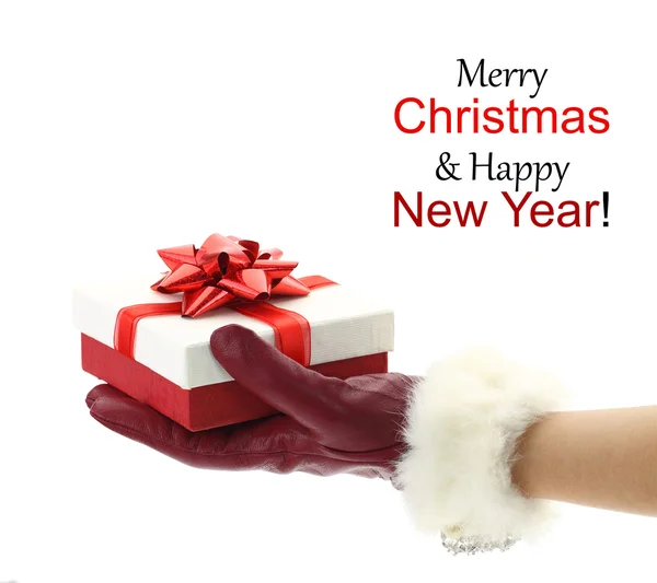 Rękę z czerwona rękawiczka trzyma prezent na Boże Narodzenie — Zdjęcie stockowe