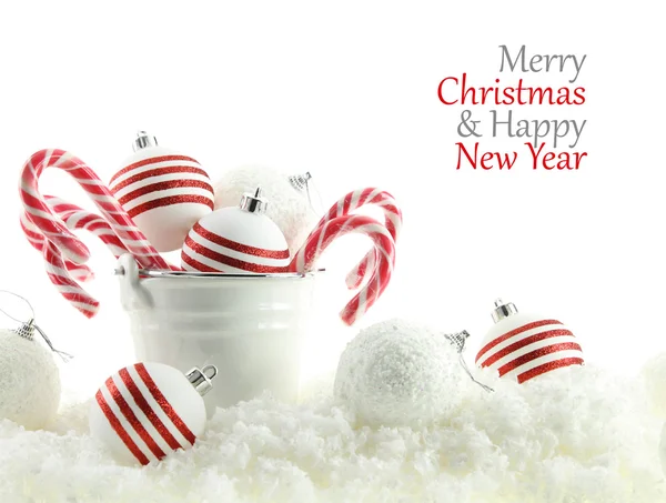 Bolas de Navidad y caramelos en una taza en la nieve — Foto de Stock