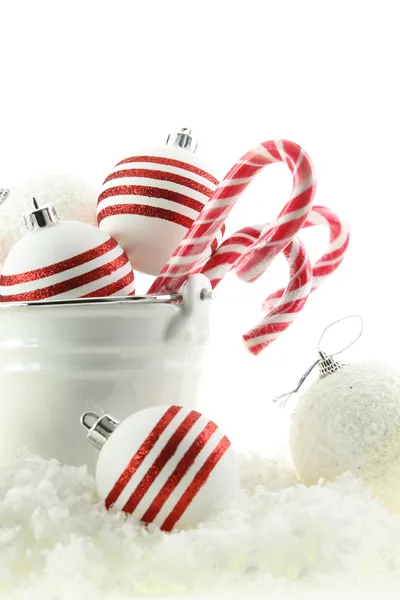 Palle di Natale e caramelle in una tazza sulla neve — Foto Stock