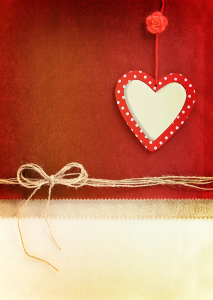 Hjärtat prydnad hängande på vintage tyg bakgrund — Stockfoto