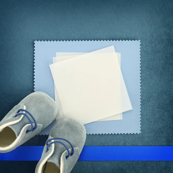 Cartão em branco com sapatos de bebê no fundo azul — Fotografia de Stock