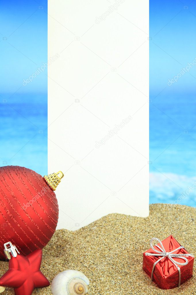 White banner and Christmas ornaments on the beach