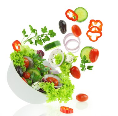 Fresh mixed vegetables falling into a bowl of salad clipart