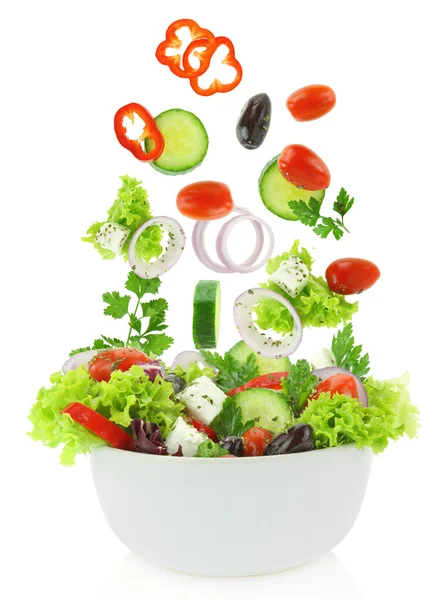 Fresh mixed vegetables falling into a bowl of salad Stock Photo