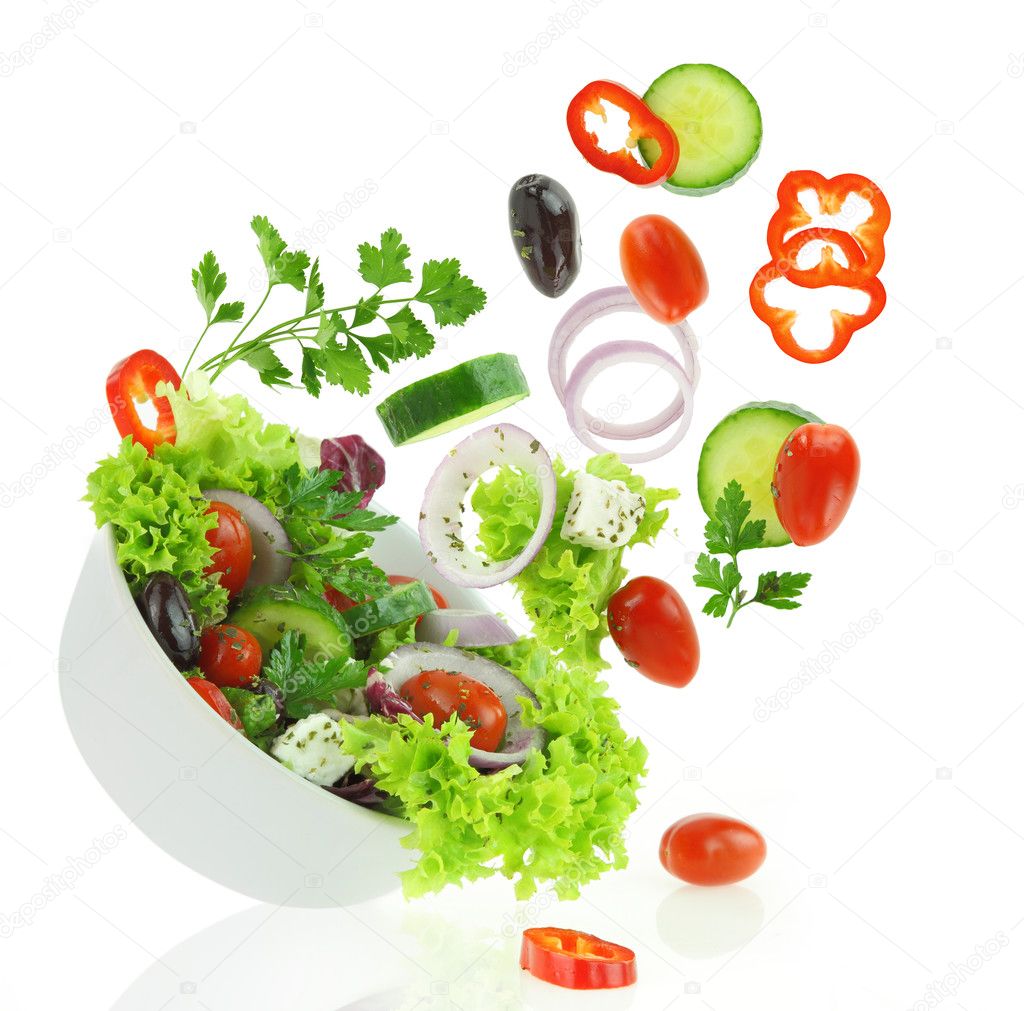 Fresh mixed vegetables falling into a bowl of salad