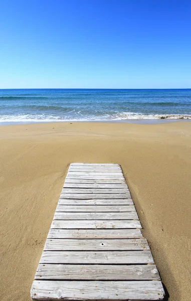 Piso de madeira na praia de areia dourada — Fotografia de Stock