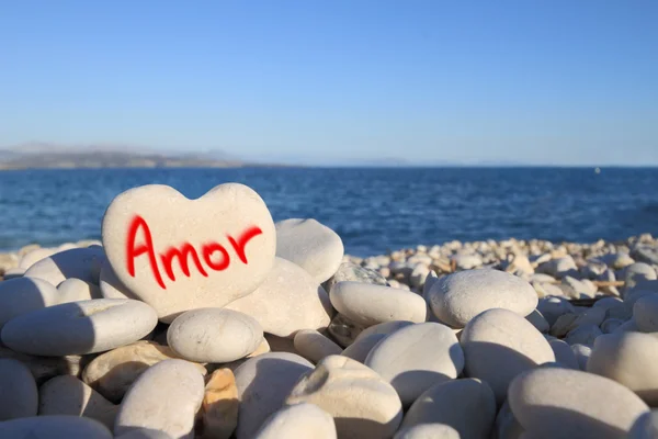 Amor escrito en piedra en forma de corazón en la playa — Foto de Stock