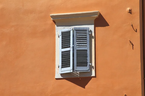 Portas de janela parcialmente abertas na parede laranja — Fotografia de Stock