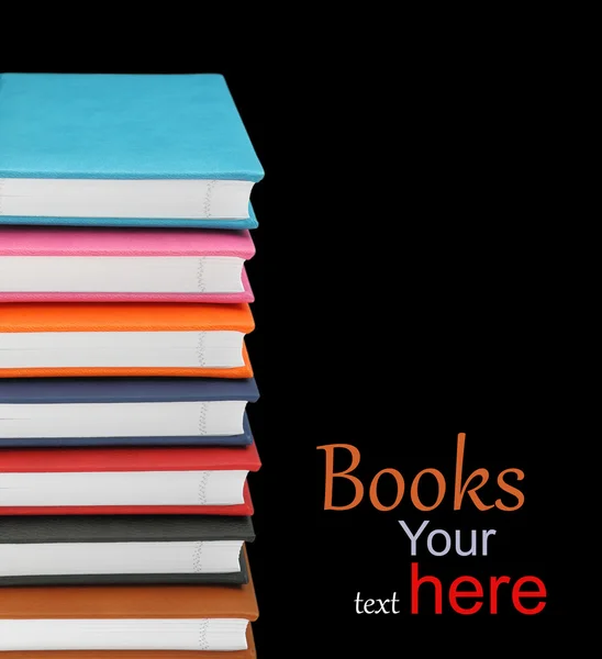 Stack of colorful books on black background — Stockfoto