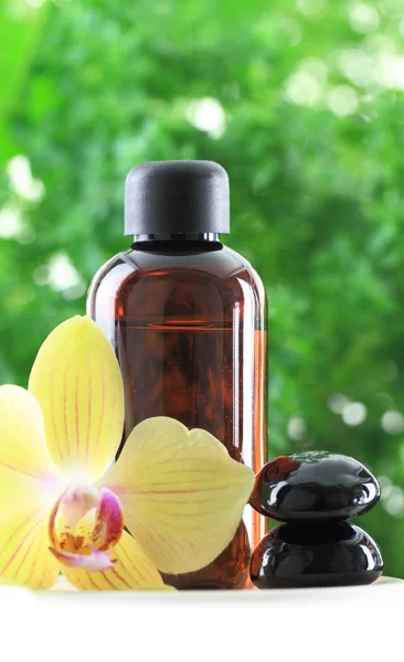 Bottle of essential oil with orchid flower and zen stones — Stock Photo, Image