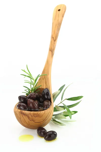 Aceitunas en una cuchara de madera sobre fondo blanco — Foto de Stock