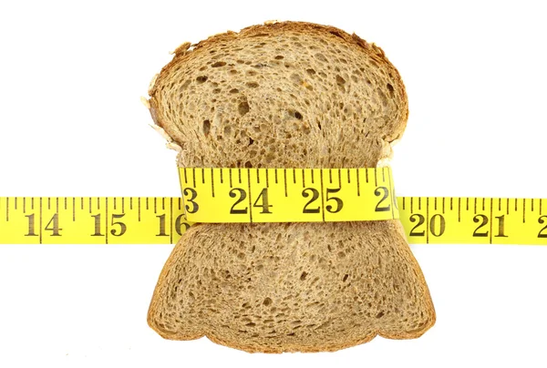Wholesome slice of bread with measuring tape isolated on white — Stock Photo, Image