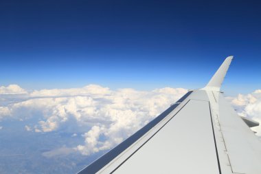Blue horizon and huge clouds, aerial shot from airplane, with wing visible clipart