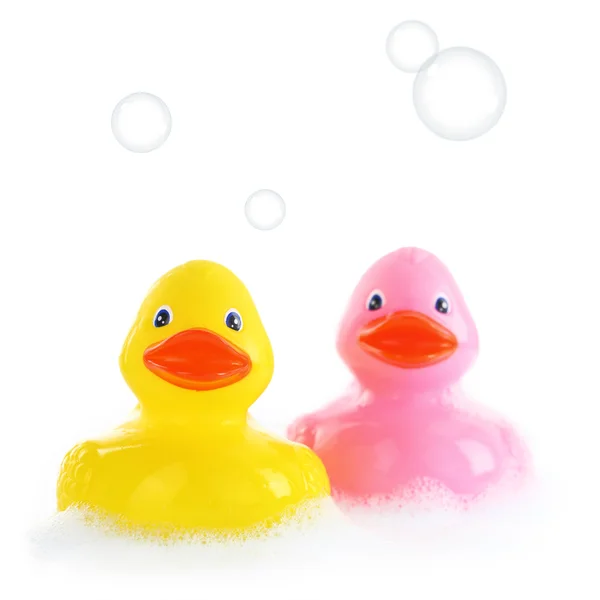 Yellow and pink rubber ducks in bath foam — Stock Photo, Image