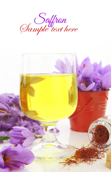 Glaset upp saffran te och saffran blommor — Stockfoto