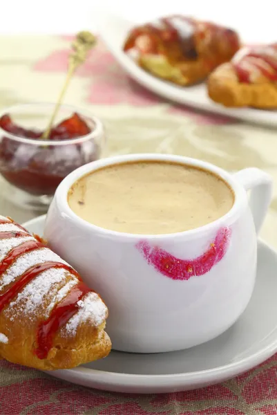 1874. kopp kaffe med läppstift mark och croissant med jordgubbssylt — Stockfoto