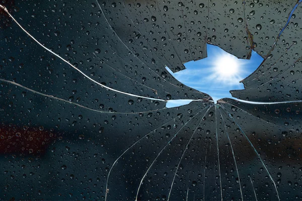 Blue sky sunny day behind a broken glass — Stock Photo, Image