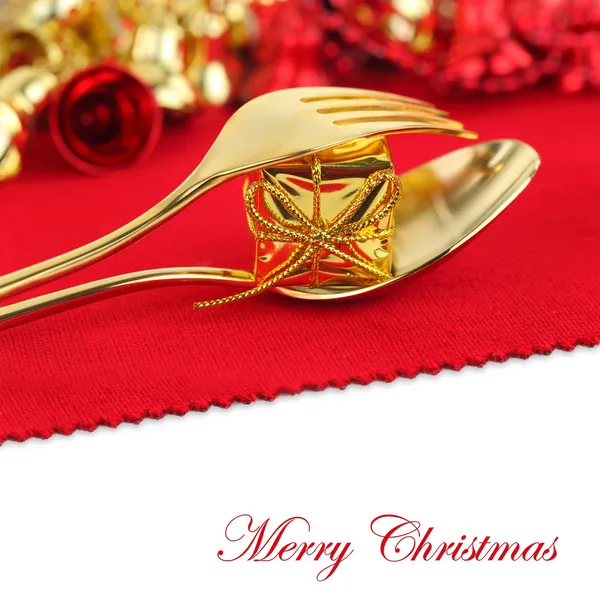 Posate natalizie dorate con ornamento su sfondo rosso — Foto Stock