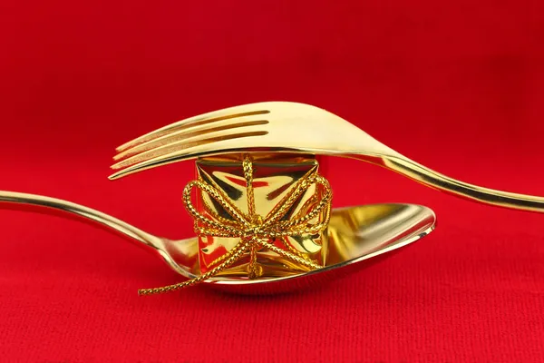 Christmas golden cutlery with ornament on red background