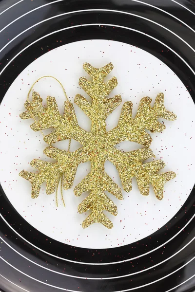 Copo de nieve de oro de Navidad en un plato — Foto de Stock