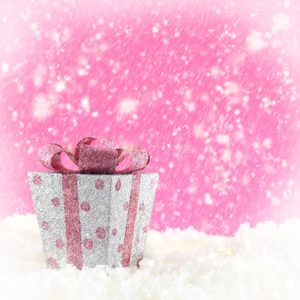 Present box with snow and pink background — Stock Photo, Image