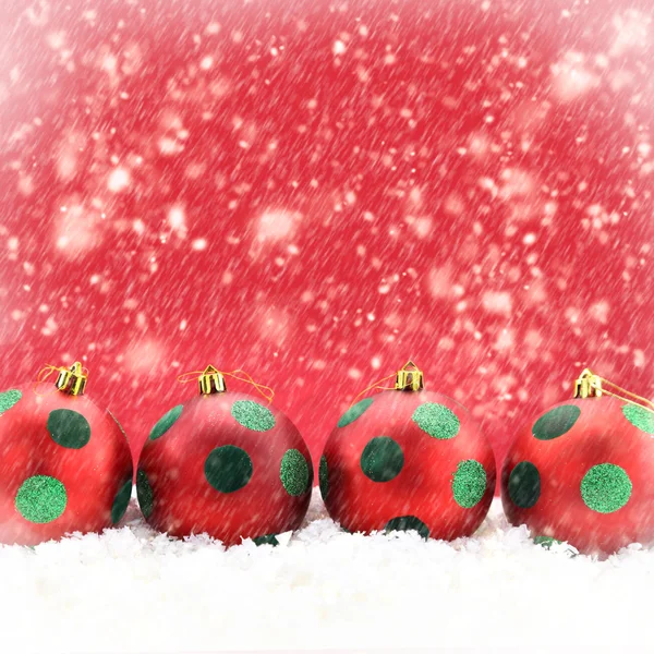 Red Christmas balls on snowing background — Stock Photo, Image