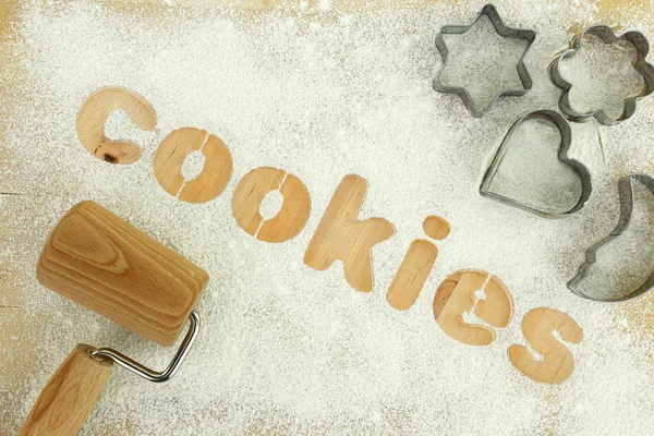 単語「クッキー」木製のテーブルの上に小麦粉で作られたステンシルします。 — ストック写真