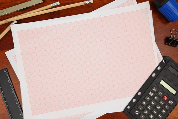 Cross-section paper with pencils on wooden background — Stock Photo, Image