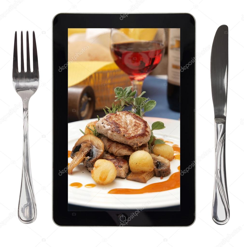Tablet with food photo, fork and knife, conceptual