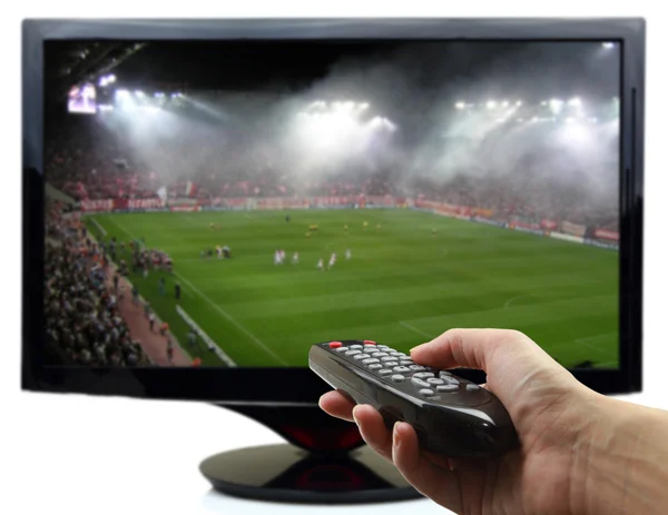 TV screen with football match and hand with remote control — стоковое фото