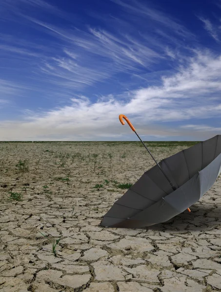 Trockene menschenleere Landschaft mit offenem schwarzen Regenschirm. — Stockfoto