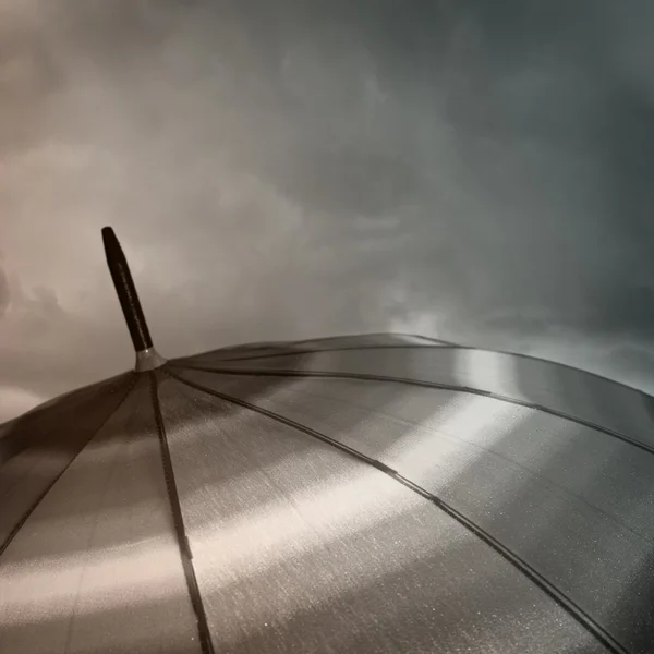 Umbrella top com gotas de chuva e nuvens pesadas — Fotografia de Stock