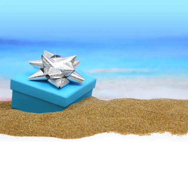 Gift box with ribbon on the sand — Stock Photo, Image