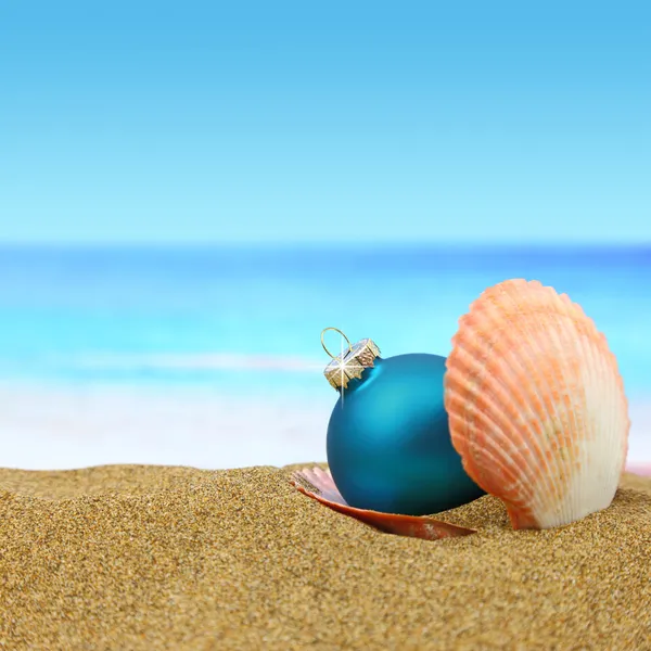 Bola de hristmas en una concha de mar en la playa —  Fotos de Stock