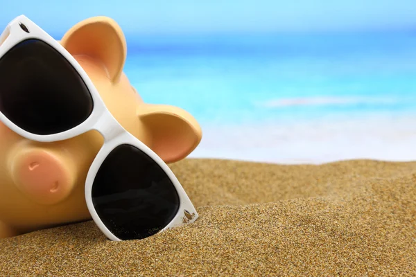 Sommer-Sparschwein mit Sonnenbrille am Strand — Stockfoto