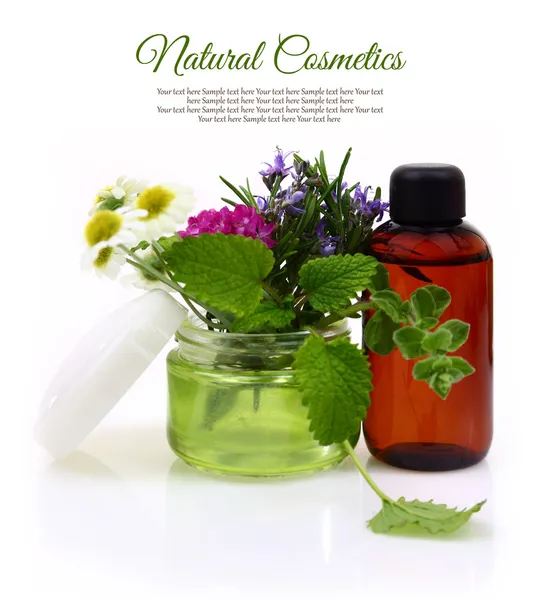 Cosmetic cream jar with herbs inside and essential oil bottle — Stock Photo, Image