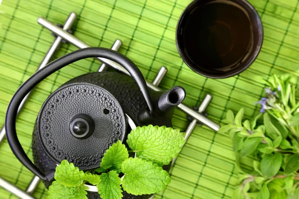 Tischplatte mit orientalischer Teekanne und Tasse mit frischen Kräutern — Stockfoto